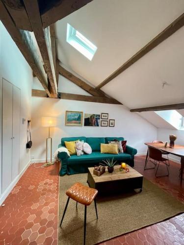 un salon avec un canapé vert et une table dans l'établissement Loft apartment at Villa Leonie, à Hyères