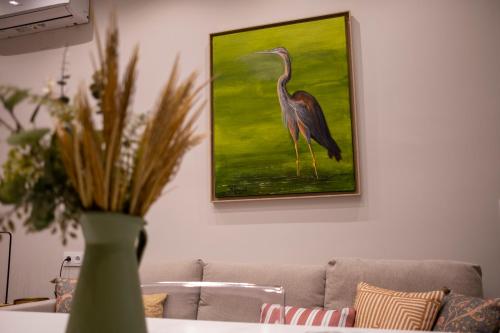 a painting of a bird on a wall next to a couch at Garza Imperial - Puente del Rey I in El Rocío