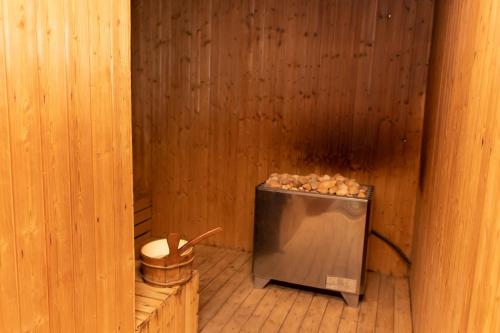 a sauna with a small refrigerator in a wooden room at Highlands Suites Hotel and Apartments in Kigali