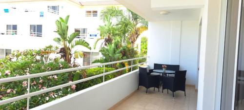 balcón con mesa, sillas y plantas en Nissi 3 Pool View Apartment en Ayia Napa