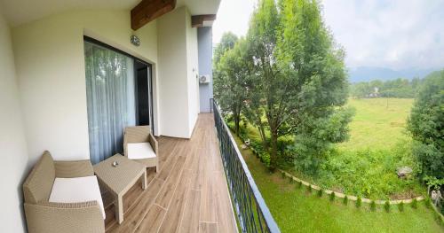 a balcony with chairs and a view of a field at Ilidža Park Apartments in Sarajevo