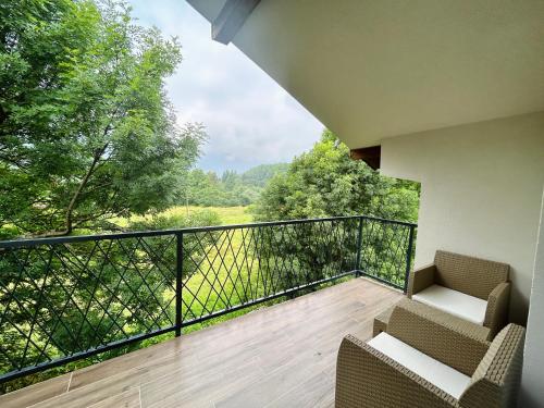 a balcony with two chairs and a view of trees at Ilidža Park Apartments in Sarajevo
