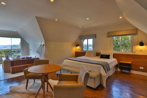カンポス・ド・ジョルドンにあるTi Voglio Beneのベッドルーム1室(ベッド1台、テーブル、椅子付)