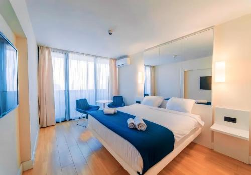 a bedroom with a large bed with a blue blanket at ORBI CITY lux studio apartment in Batumi