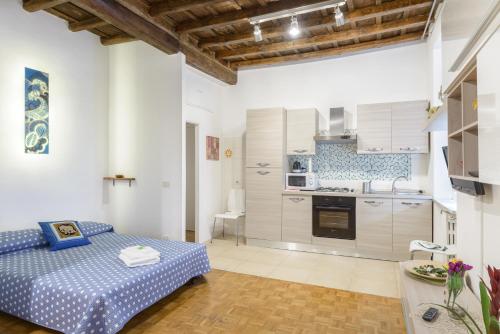 ローマにあるCasa Tua a Montiのリビングルーム(ベッド1台付)、キッチンが備わります。