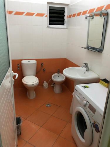 a bathroom with a toilet sink and a washing machine at STEFAN VASILI in Sarandë
