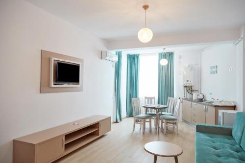 a living room with a blue couch and a kitchen at Excelsior apartaments 2 mamaia nord in Mamaia Nord