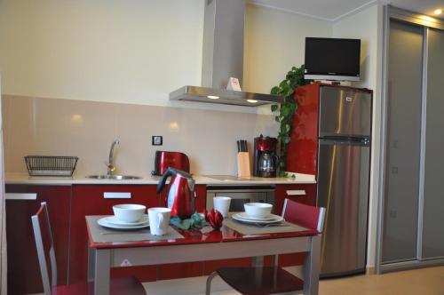 a kitchen with a table and a red refrigerator at Aparthotel Safari in Calella
