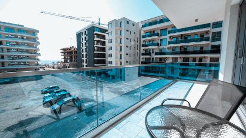 ein Balkon mit einem Swimmingpool auf einem Gebäude in der Unterkunft WAVE 4 Apartments Mamaia Nord in Năvodari