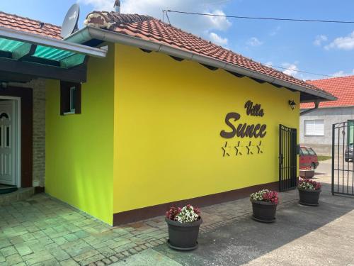 a yellow building with the words the same on it at Vila Sunce Morovic in Morović