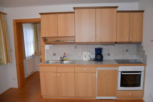 a kitchen with wooden cabinets and a sink at Biohof Teufel in Lunz am See