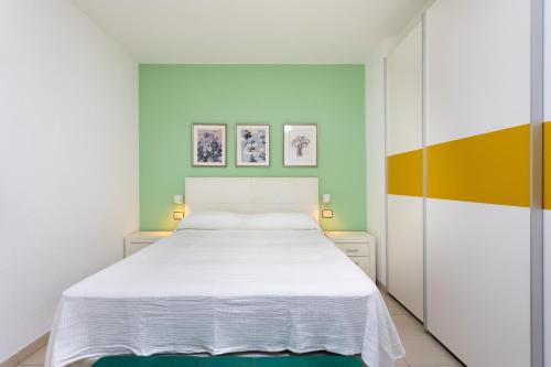 um quarto com uma cama branca e paredes verdes em EDEN RENTALS Pure Oasis Ocean Views em El Rosario
