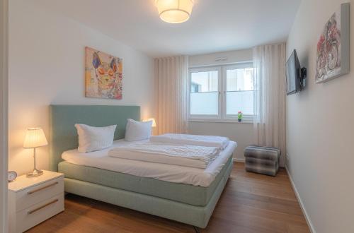 um pequeno quarto com uma cama e uma janela em Hafenresidenz Waren (Müritz) em Waren