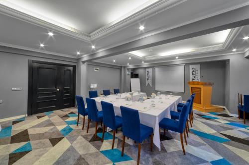 uma sala de conferências com uma mesa branca e cadeiras azuis em Numa Port Hotel em Alanya