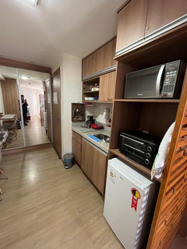 a kitchen with a refrigerator and a microwave at Vista da Pedra Flat in Pedra Azul