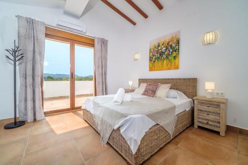 a bedroom with a bed and a large window at Villa La Sella by Rock Rentals in Muntanya la Sella