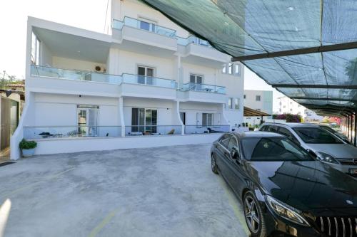 a black car parked in front of a white building at Vila Enxhi in Ksamil