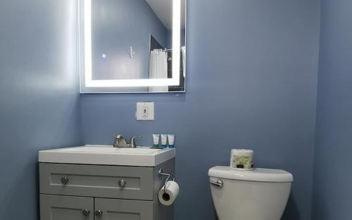 a blue bathroom with a toilet and a sink at Glenghorm Beach Resort in Ingonish