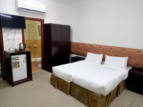 Un pat sau paturi într-o cameră la فندق نبض الضيافة 1 - العزيزية الشارع العام