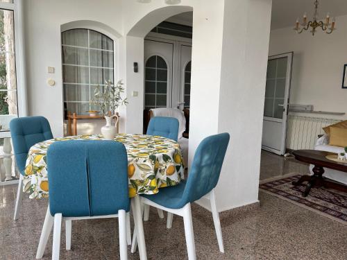 ein Esszimmer mit einem Tisch und blauen Stühlen in der Unterkunft Apartments Sana in Sveti Stefan
