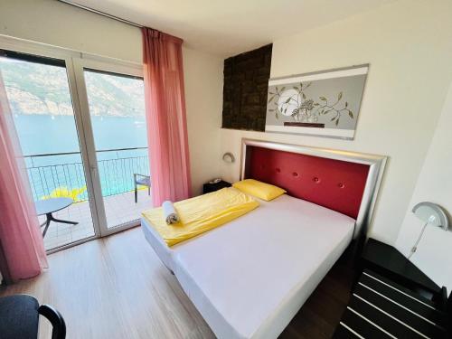 a bedroom with a bed and a balcony at Hotel Villa Carmen in Malcesine