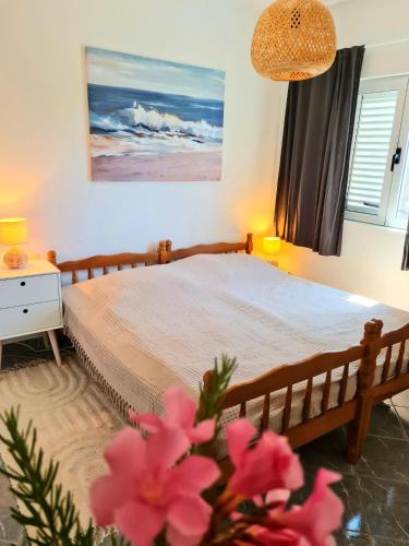 a bedroom with a bed with pink flowers in the foreground at Natua Apartment in Krvavica