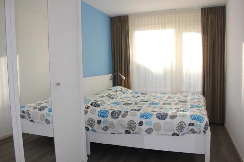 um pequeno quarto com uma cama e uma janela em Amelander Paradijs 22 em Buren