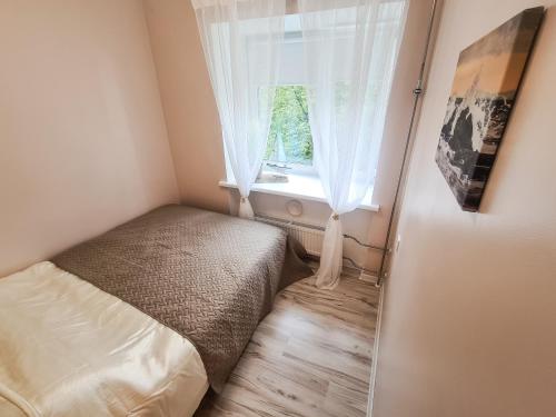a small bedroom with a bed and a window at Tammsaare 28 Beach Apartment in Pärnu