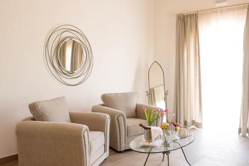 a living room with two chairs and a table and a mirror at Casa Font i Roig in Maria de la Salut