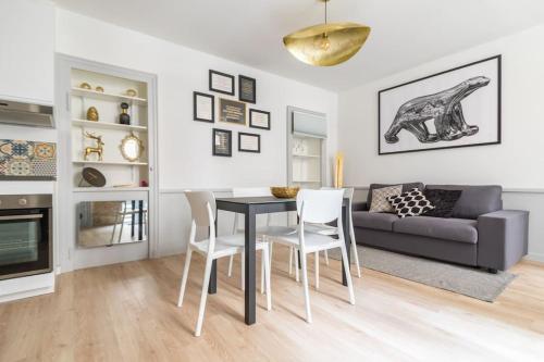 un salon avec une table, des chaises et un canapé dans l'établissement Chez Maya, à Dijon