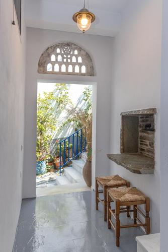 a hallway with two benches and an archway with a window at Βόλτα Καλλονή studio (Volta Kalloni) in Kalloni Tinou