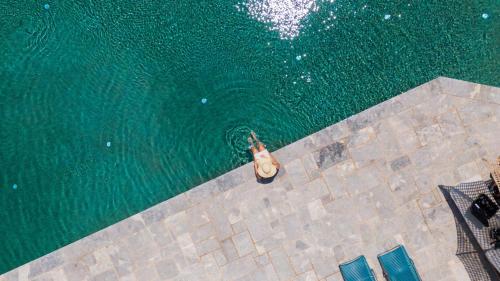 an overhead view of a person swimming in the water at Petra & Fos Boutique Hotel & Spa in Neon Oitilon