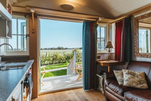 uma cozinha e sala de estar com uma grande porta de vidro deslizante em Hornington Manor Luxury Shepherd Huts em York