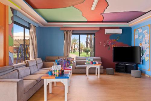 a living room with a couch and a flat screen tv at Pickalbatros Aqua Fun Club All Inclusive in Marrakech