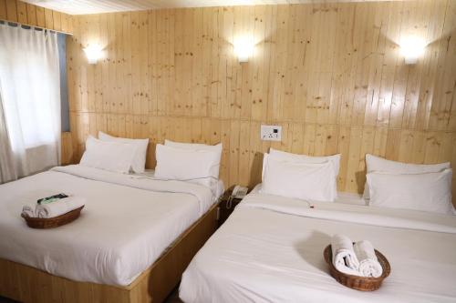 - 2 lits dans une chambre dotée de murs en bois dans l'établissement Hotel Fifth Season Pahalgam, à Pahalgām