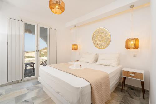 um quarto branco com uma cama e uma janela em Celestial Seaview Apartments- Ariadne em Naxos Chora