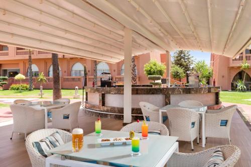 a patio with tables and chairs and a grill at Pickalbatros Aqua Fun Club All Inclusive in Marrakech