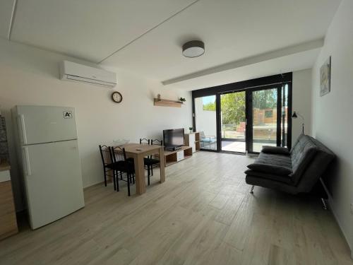 Il dispose d'une cuisine et d'un salon avec une table et un réfrigérateur. dans l'établissement Szemesi Apartman, à Balatonszemes