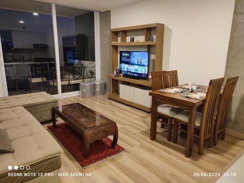 uma sala de estar com um sofá, uma mesa e uma televisão em Mar Adentro Hermoso departamento en la Playa con vista al Mar em Naranjalito