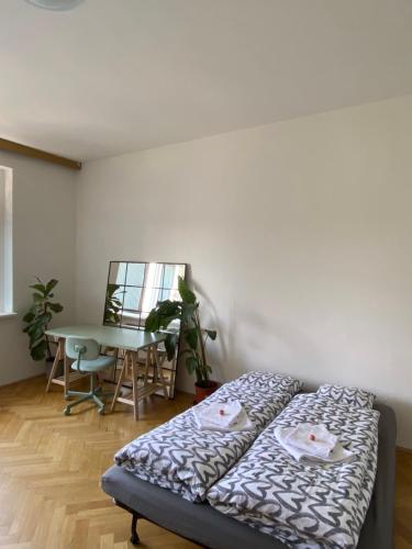 un letto in una stanza con tavolo e tavolo di Soukromý pokoj v třípokojovém bytě - Private room in three room flat a Brno
