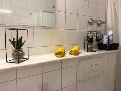 a bathroom counter with two yellow towels and a mirror at Adler Apartment in Cologne