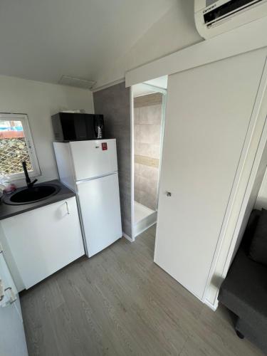 une cuisine avec un réfrigérateur blanc et une fenêtre dans l'établissement Europcamping, à Fréjus