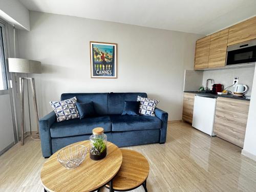 un salon avec un canapé bleu et une table dans l'établissement La douceur de vivre à Cannes, à Cannes