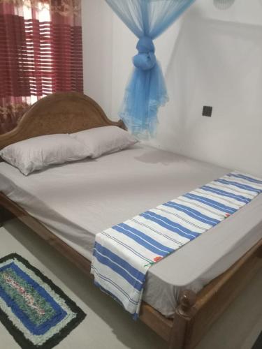 a bedroom with a bed with a blue canopy at Thisumi Guest in Weligama