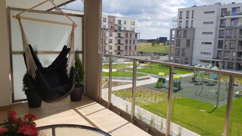 a hammock in a balcony with a view of a city at Apartament Flat 33 Suwałki in Suwałki