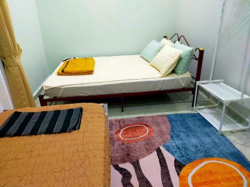a small room with a bed and a rug at WK HOMESTAY PASIR MAS in Pasir Mas