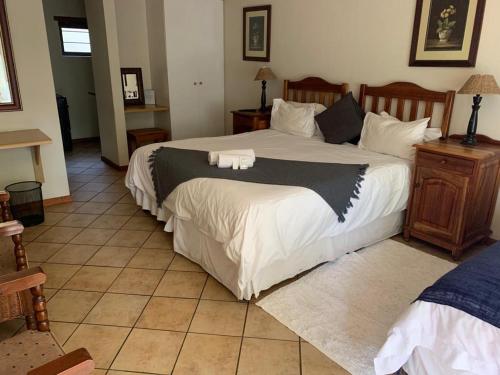 - une chambre avec un grand lit et des draps blancs dans l'établissement Schoongezich Guesthouse, à Pretoria