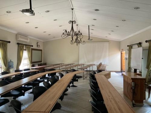une salle de classe avec des bureaux et des chaises dans l'établissement Schoongezich Guesthouse, à Pretoria