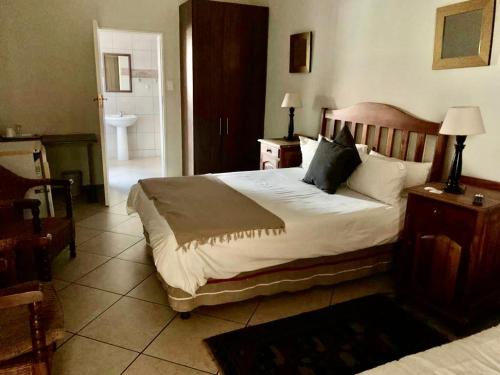 - une chambre avec un grand lit et une salle de bains dans l'établissement Schoongezich Guesthouse, à Pretoria
