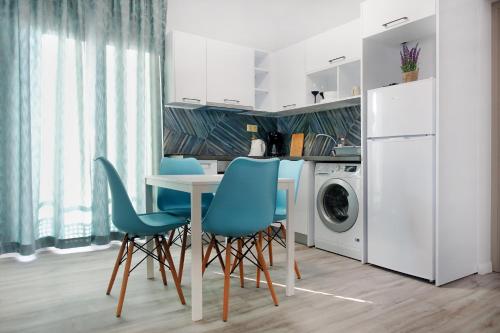cocina con mesa, sillas y lavadora en Okean Apartments, en Ierissos